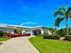 Charming home exterior with well-manicured lawn, lush landscaping, and vibrant red and blue accents at 14230 86Th Ter, Seminole, FL 33776