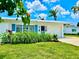 This home features a lush green lawn and tasteful landscaping, enhancing its curb appeal beneath a bright, sunny sky at 14230 86Th Ter, Seminole, FL 33776