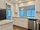 Stylish kitchen with stainless steel dishwasher, granite countertops, and white cabinets offering a modern design at 14230 86Th Ter, Seminole, FL 33776