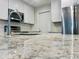 Close-up of granite countertops, stainless appliances, and updated cabinetry create a sleek, modern kitchen space at 14230 86Th Ter, Seminole, FL 33776