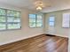Living room with multiple windows, wood flooring, and ceiling fan at 14230 86Th Ter, Seminole, FL 33776
