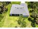 Aerial shot of the house showcasing a well-maintained roof, screened lanai, and surrounding green lawn at 14422 Chamberlain Blvd, Port Charlotte, FL 33953