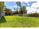Lush backyard featuring green grass, mature trees, and a privacy fence at 14422 Chamberlain Blvd, Port Charlotte, FL 33953
