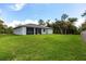 Expansive backyard featuring a screened lanai and lush green lawn, perfect for outdoor living and entertaining at 14422 Chamberlain Blvd, Port Charlotte, FL 33953