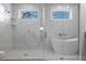 Elegant bathroom with glass enclosed shower, white tub, and bright windows at 14422 Chamberlain Blvd, Port Charlotte, FL 33953