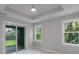 Bedroom with sliding glass door access to patio, tray ceiling, and marble floors at 14422 Chamberlain Blvd, Port Charlotte, FL 33953