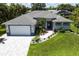 Beautiful home exterior with a well-manicured lawn, paver driveway, and tasteful landscaping at 14422 Chamberlain Blvd, Port Charlotte, FL 33953