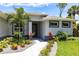 Stunning home's front entrance is accentuated with vibrant landscaping and a paved walkway at 14422 Chamberlain Blvd, Port Charlotte, FL 33953