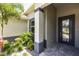Close up of front entrance with a sturdy door, stone column and vibrant landscaping at 14422 Chamberlain Blvd, Port Charlotte, FL 33953