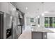 Kitchen featuring a spacious island with marble countertops, gray cabinets, stainless steel appliances and natural lighting at 14422 Chamberlain Blvd, Port Charlotte, FL 33953