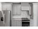 Modern kitchen featuring gray cabinets, stainless steel appliances, and marble countertops at 14422 Chamberlain Blvd, Port Charlotte, FL 33953