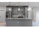 Modern kitchen with marble countertops and backsplash, gray cabinets, stainless steel appliances and island seating at 14422 Chamberlain Blvd, Port Charlotte, FL 33953
