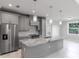 Modern kitchen with a spacious island, marble countertops, gray cabinets and stainless steel appliances and a view at 14422 Chamberlain Blvd, Port Charlotte, FL 33953