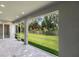 Open screened lanai with a gray brick floor that looks out on a grassy backyard at 14422 Chamberlain Blvd, Port Charlotte, FL 33953