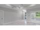 Bright, open living area with white marble floors, tray ceiling and sliding glass doors leading to the outside at 14422 Chamberlain Blvd, Port Charlotte, FL 33953