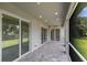 Covered outdoor patio with stone flooring and views of the landscaped yard at 14422 Chamberlain Blvd, Port Charlotte, FL 33953