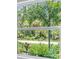 Bright window view with tropical landscaping with lush palm trees and flowering shrubs outside the window at 14422 Chamberlain Blvd, Port Charlotte, FL 33953