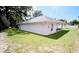 View of the home's back exterior and well-maintained backyard, surrounded by mature trees at 1536 Palmetto St, Clearwater, FL 33755