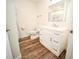 Well-lit bathroom showcasing vanity, toilet and tub shower with wood-look flooring at 1536 Palmetto St, Clearwater, FL 33755