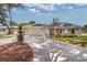 Beautiful single-story home with a two-car garage, lush landscaping, and a curved driveway at 1536 Palmetto St, Clearwater, FL 33755