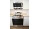 Close up of a modern stainless steel oven and stove with granite countertops and white cabinets at 1536 Palmetto St, Clearwater, FL 33755