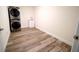 A laundry room featuring a stackable washer and dryer, wood-look flooring, and a wash sink at 1536 Palmetto St, Clearwater, FL 33755