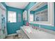 Bathroom with a white vanity, granite countertop, turquoise walls, and a decorative mirror at 1632 Ridge Top Way, Clearwater, FL 33765