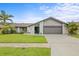 Charming home with a well-manicured lawn, lush landscaping, and a two-car garage at 1632 Ridge Top Way, Clearwater, FL 33765