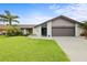 Charming single-story home with well-manicured lawn, tropical landscaping, and two-car garage at 1632 Ridge Top Way, Clearwater, FL 33765