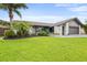 Charming single-story home with well-manicured lawn, tropical landscaping, and painted brick exterior at 1632 Ridge Top Way, Clearwater, FL 33765