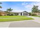 Single-story home featuring a lush front lawn with mature landscaping and a two-car garage at 1632 Ridge Top Way, Clearwater, FL 33765