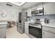 Modern kitchen with stainless steel appliances, light grey cabinets, and open access to the dining area at 1632 Ridge Top Way, Clearwater, FL 33765