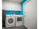 A bright laundry room offers white appliances and cabinet storage at 1632 Ridge Top Way, Clearwater, FL 33765