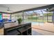 Screened-in lanai with dark wicker furniture, ceiling fan, and a view of the pool at 1632 Ridge Top Way, Clearwater, FL 33765