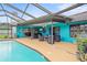 This pool area features a covered patio, an outdoor dining area, and plenty of space for entertaining at 1632 Ridge Top Way, Clearwater, FL 33765