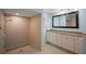 Modern bathroom featuring a tiled shower and a vanity with double sinks and granite countertops at 17 Freshwater Dr, Palm Harbor, FL 34684