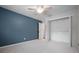 Bedroom with blue accent wall, carpet floors, ceiling fan, and a closet at 17 Freshwater Dr, Palm Harbor, FL 34684