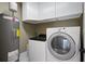 A well-equipped laundry room featuring a washer, dryer, water heater, and white cabinetry at 17 Freshwater Dr, Palm Harbor, FL 34684