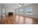 Bright living room featuring hardwood floors, three windows with waterfront views, and a grand piano at 17 Freshwater Dr, Palm Harbor, FL 34684