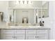 Bathroom features a double sink vanity with white cabinets, granite countertops, and large framed mirrors at 1732 Flamingo Ln, Sun City Center, FL 33573