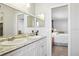Bright bathroom with a double sink vanity and granite countertops opens into the adjacent bedroom at 1732 Flamingo Ln, Sun City Center, FL 33573