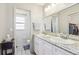 Bright bathroom features a double sink vanity with white cabinets and granite countertops, and a view into the toilet room at 1732 Flamingo Ln, Sun City Center, FL 33573