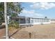 Exterior view of home, showcasing the screened-in porch, landscaping, and neutral-toned gravel yard at 1732 Flamingo Ln, Sun City Center, FL 33573