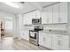 Well-lit kitchen featuring white cabinets, stainless steel appliances, and granite countertops at 1732 Flamingo Ln, Sun City Center, FL 33573