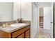 Well-lit bathroom with granite countertop and wood vanity, next to the carpeted stairs at 17378 Cruiser Bnd, Land O Lakes, FL 34638