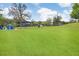 Expansive community park featuring a grassy lawn, shade trees, seating, a covered picnic area and play structures at 17378 Cruiser Bnd, Land O Lakes, FL 34638