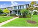 Charming townhome with a lush green lawn and manicured landscaping and trees at 17378 Cruiser Bnd, Land O Lakes, FL 34638