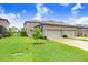 Exterior view showcasing the home's architecture, green lawn, and attached garage at 17378 Cruiser Bnd, Land O Lakes, FL 34638