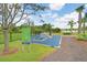 Outdoor fitness station with various exercise equipment and a sign detailing workout instructions in a green space at 17378 Cruiser Bnd, Land O Lakes, FL 34638