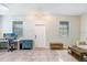 Bright living room featuring a desk, two windows, and neutral-toned tile flooring at 17378 Cruiser Bnd, Land O Lakes, FL 34638